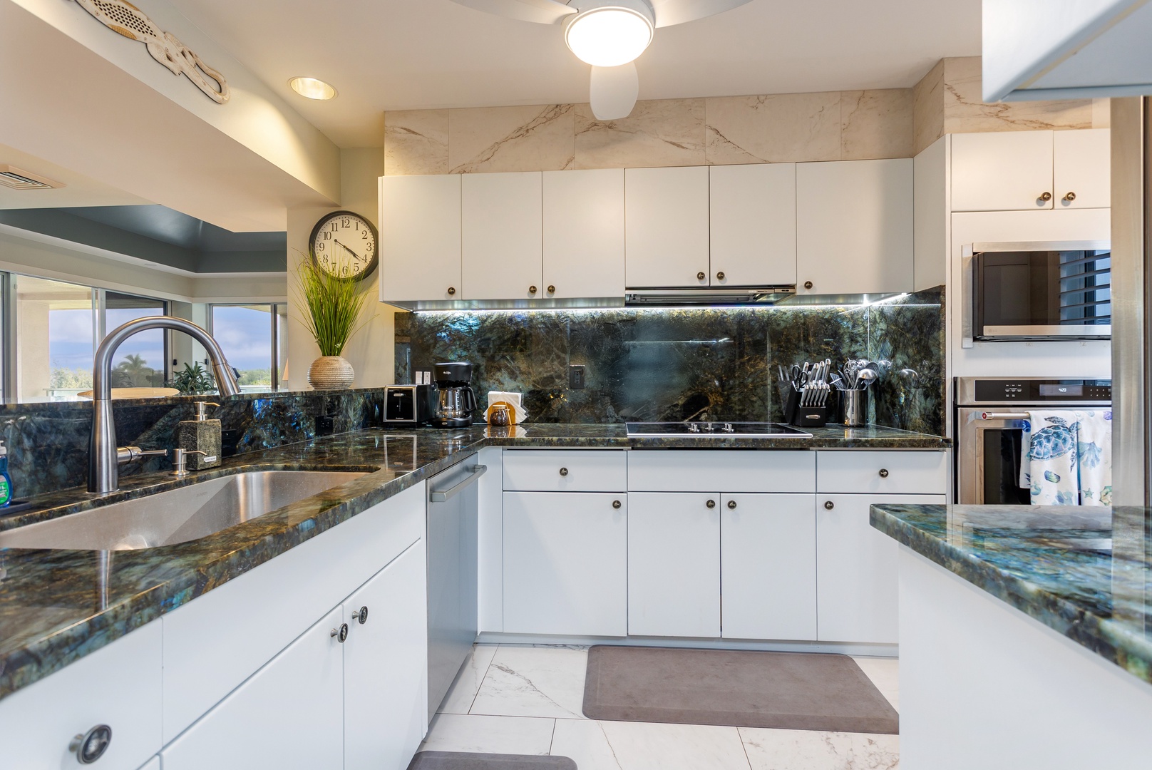Your gourmet kitchen features elegant marble backsplash, granite countertops, and premium appliances—perfect for preparing meals while enjoying natural light and stylish design.