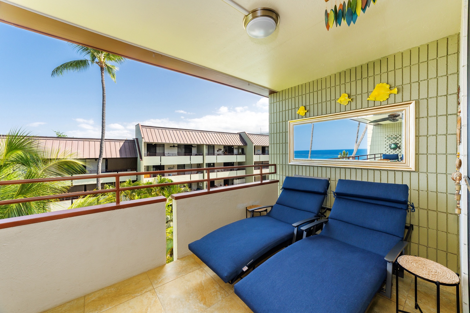 Recline on your private balcony with tropical views, where the swaying palm tree and distant ocean glimpse create the perfect Hawaiian escape.
