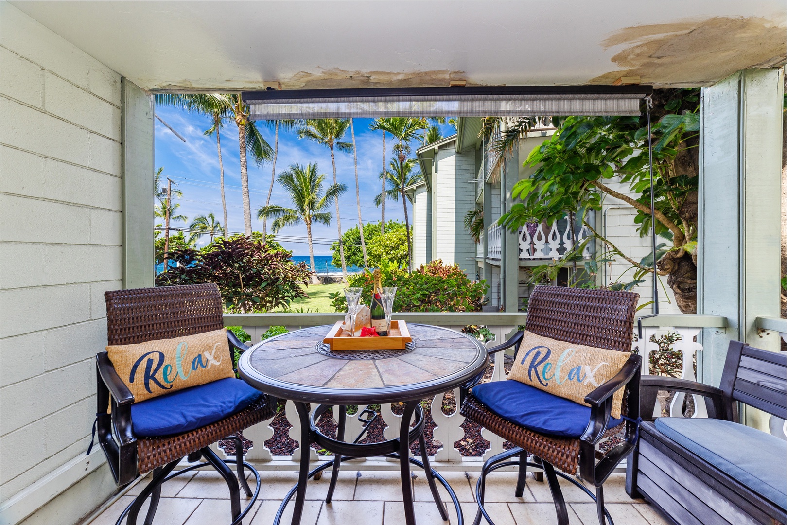 Step out to your private lanai and soak in the tropical paradise views. With cozy seating, ocean glimpses, and swaying palms framing the horizon, this is your perfect spot to unwind and sip your morning coffee.
