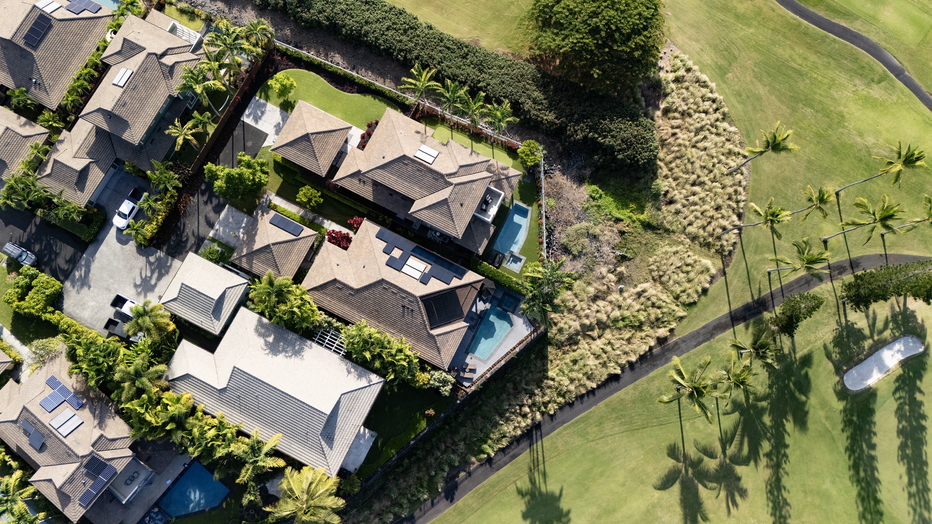Stunning aerial view of the Holua Kai resort property surrounded by lush golf course fairways and swaying palm trees.