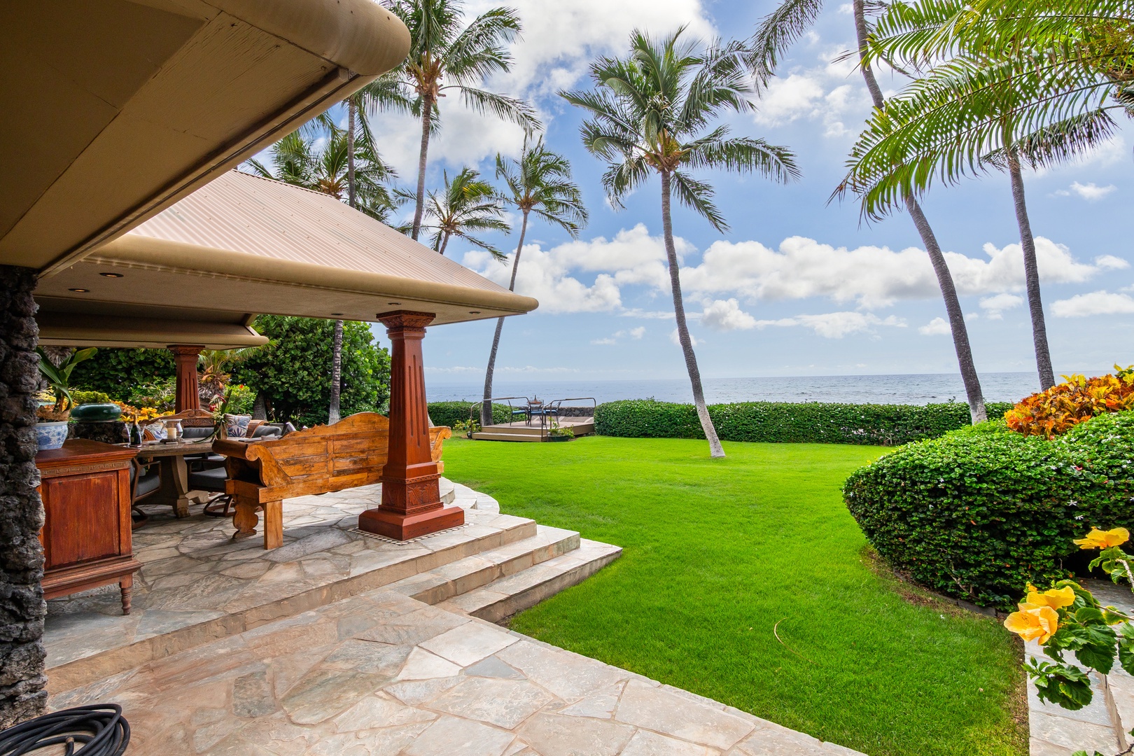 Beachfront paradise with lush lawns, swaying palms, and stunning ocean views. The covered lanai offers the perfect spot to soak in Hawaii's natural beauty.