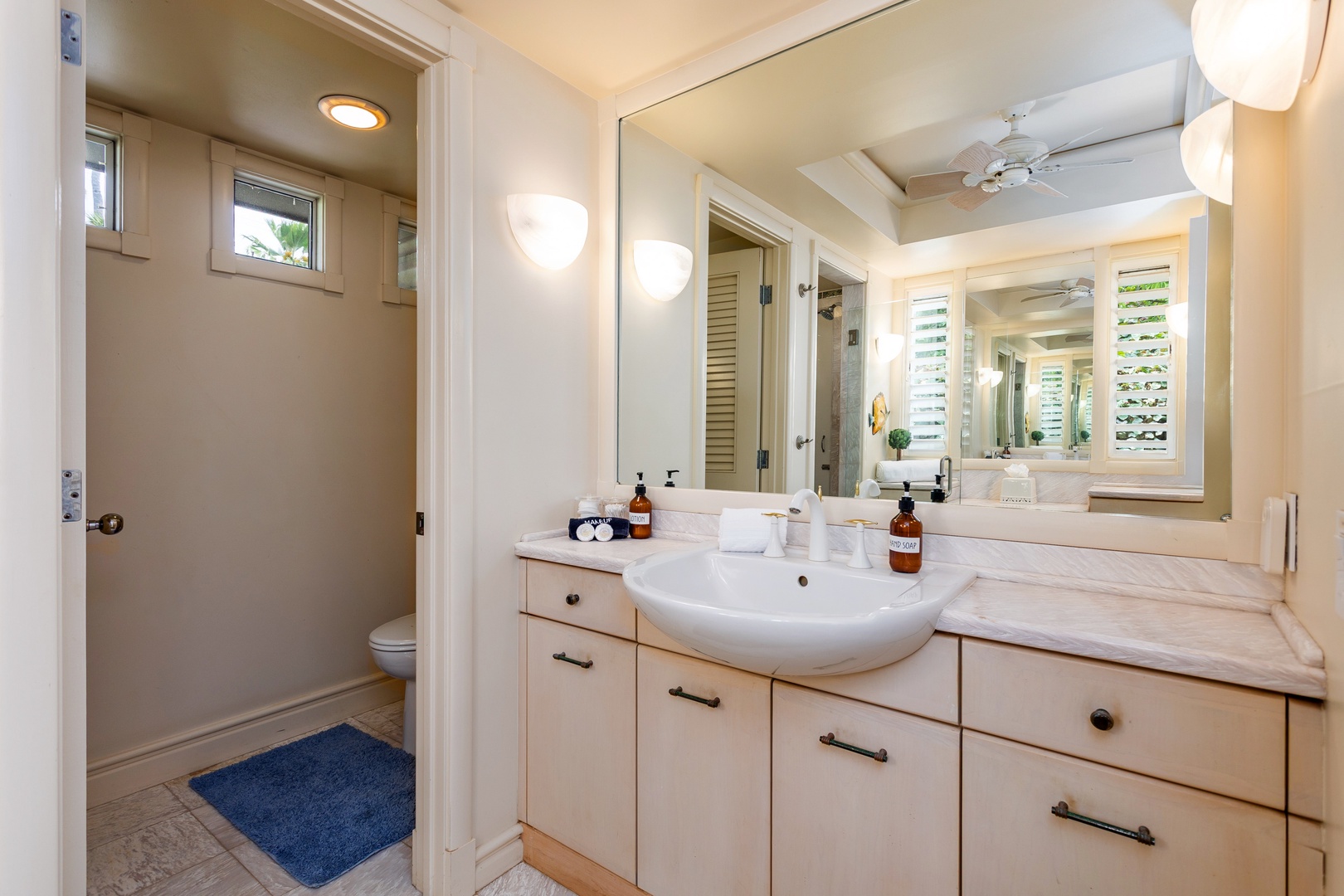 Ohana (Guest House) - Your bathroom features a stylish vanity with marble countertops, fresh towels, and quality amenities ready for you. Bright natural light from plantation shutters creates a welcoming, spa-like atmosphere.
