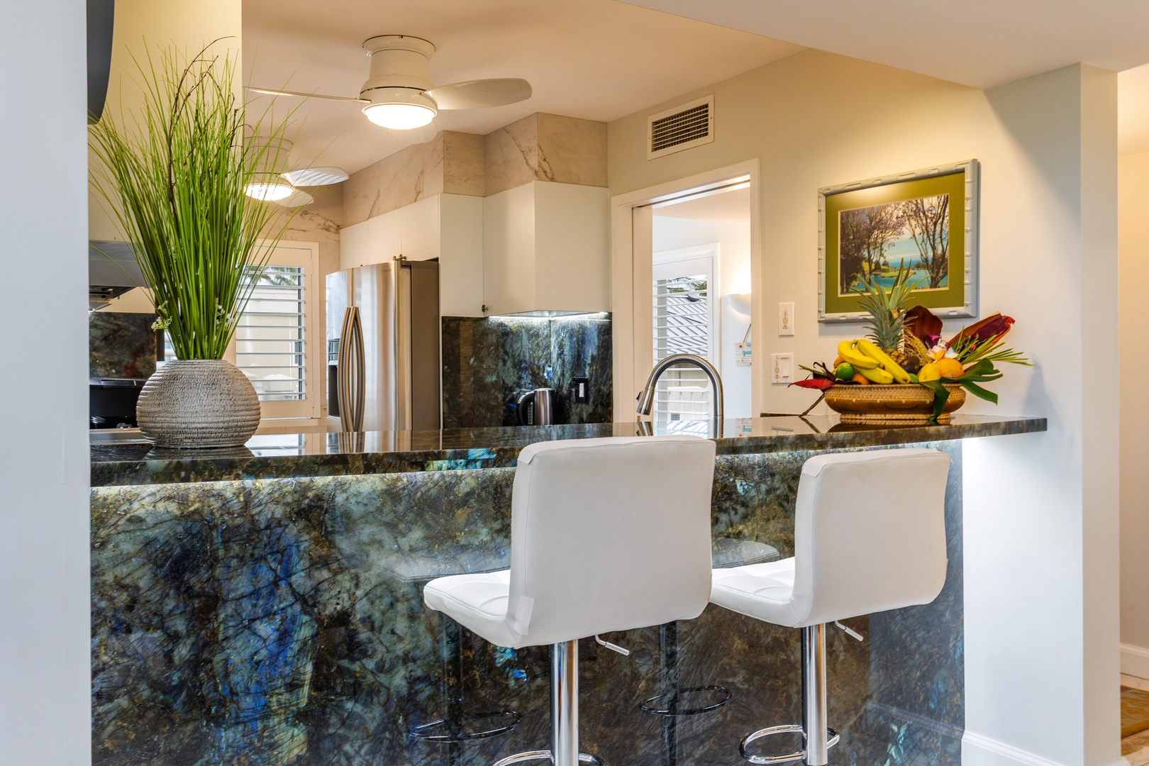 Gather at this stunning granite breakfast bar where your mornings begin with tropical flair. Sleek seating, vibrant décor, and natural light invite you to savor coffee in style.