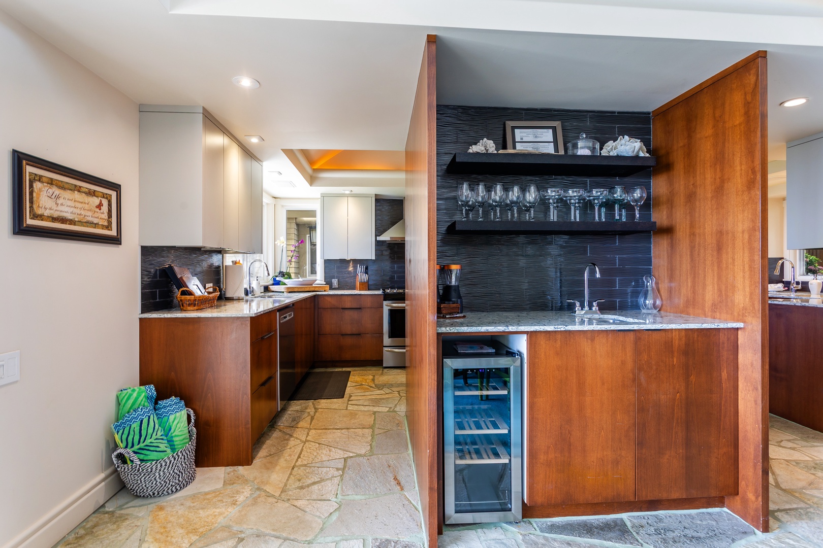 Step into your beautifully appointed kitchen, where rich wood cabinetry meets sleek design. Pour a glass from the wine cooler and gather around the spacious counters—your culinary retreat awaits.