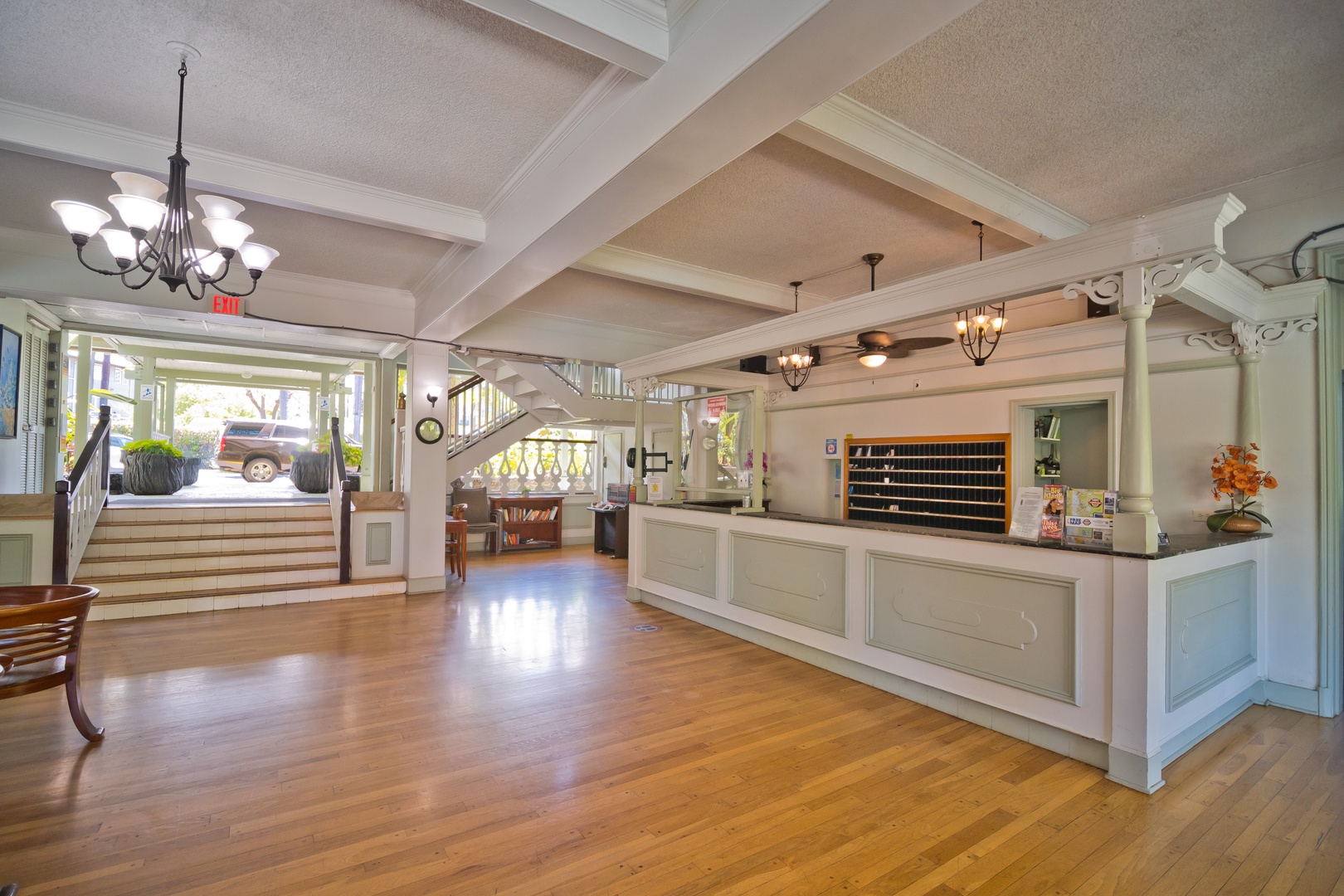 Bright and welcoming lobby with polished hardwood floors, elegant chandeliers, and a friendly reception desk ready to greet you upon arrival.