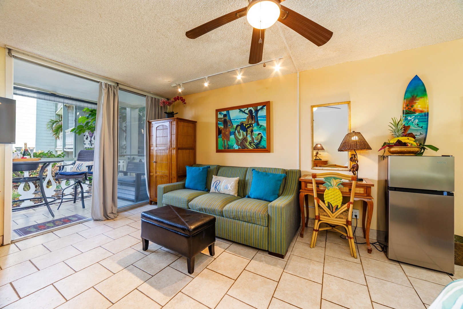 Relax in your tropical-themed living space with a comfy sofa, island artwork, and ceiling fan. Glass doors open to your private lanai for easy indoor-outdoor living.