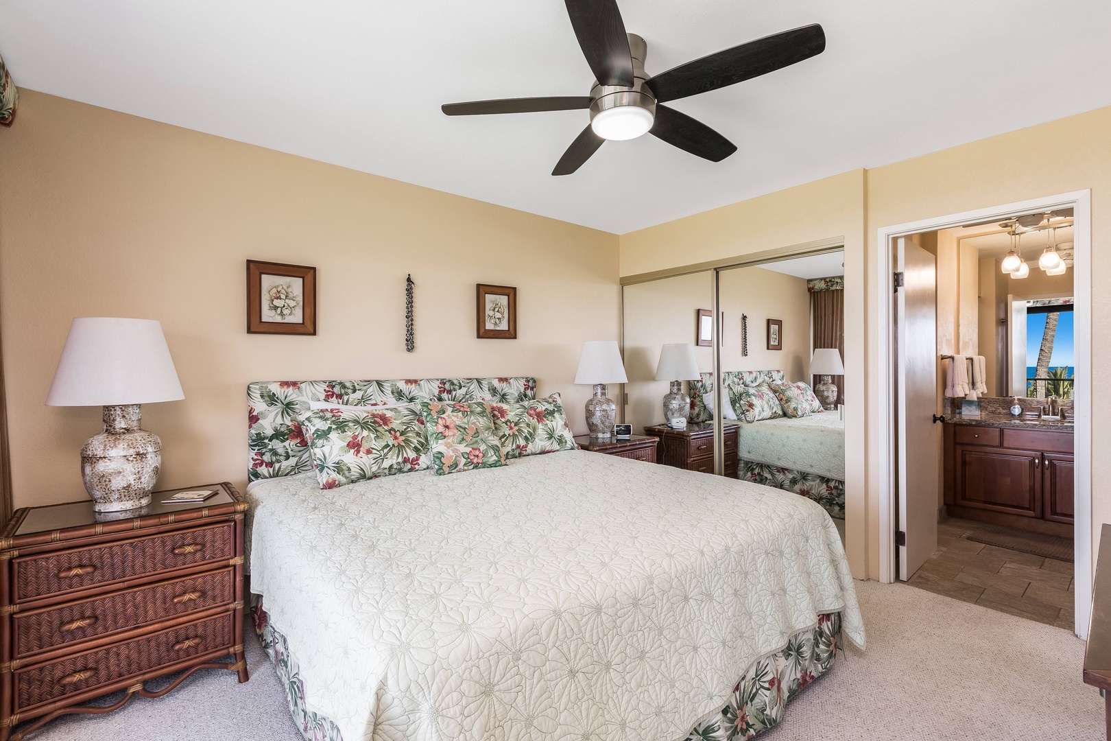 Sink into your comfortable bed with tropical-inspired linens after a day of island adventures, enjoying the ceiling fan's gentle breeze overhead.