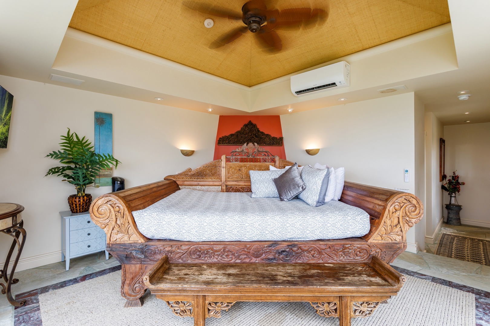 Ohana (Guest House) - Your private retreat features a stunning hand-carved wooden bed with intricate detailing, plush linens, and soft lighting overhead. Air conditioning and tropical decor create a serene, comfortable escape.