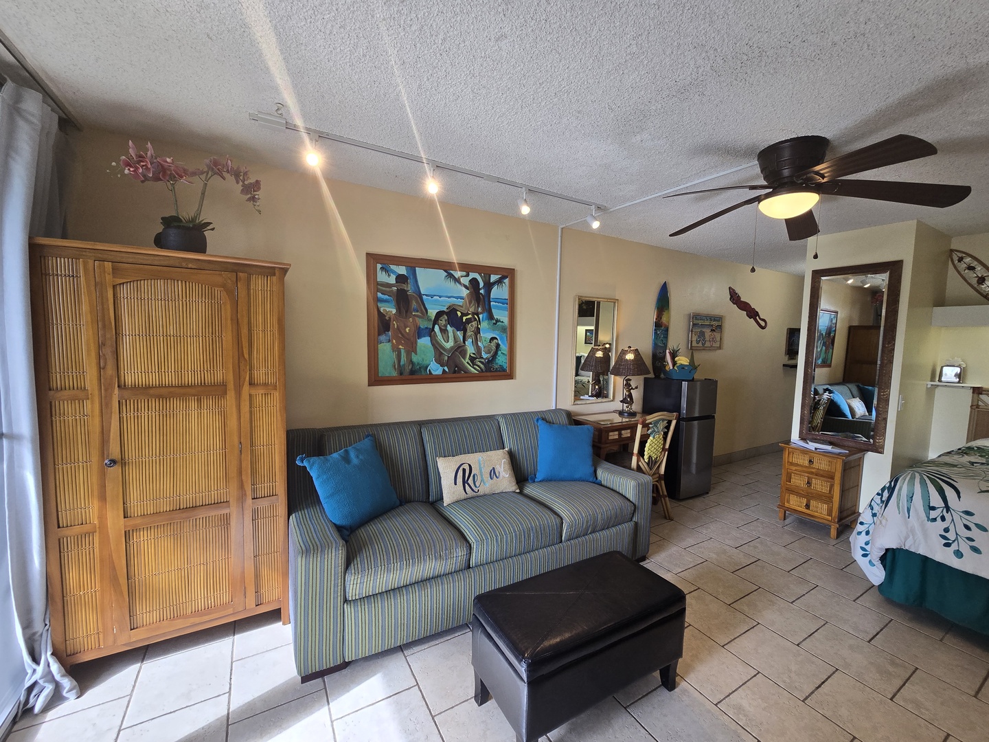 Relax in your tropical-themed living space with comfortable seating, bamboo furnishings, and coastal artwork creating the perfect beach getaway ambiance.