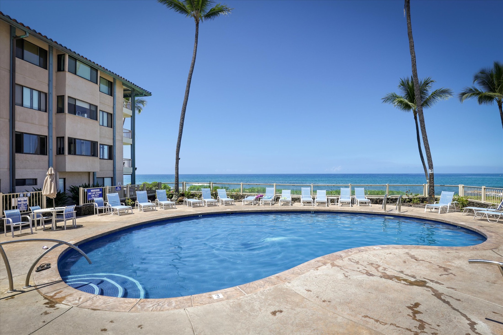 Picture yourself lounging poolside with tropical palms swaying overhead and the sparkling ocean just steps away—your Hawaiian escape awaits with sun, sea, and total relaxation.