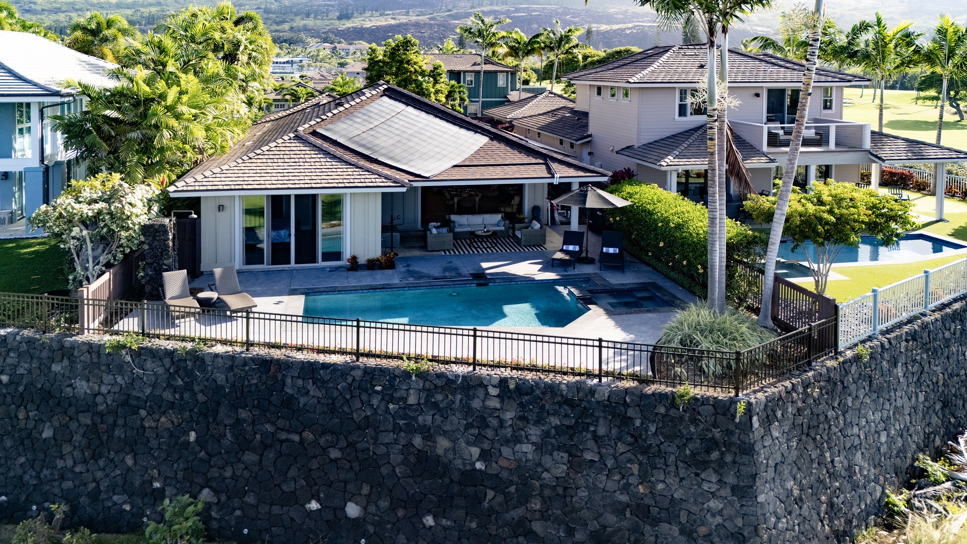 Elevated property overlooks the lush tropical landscape, offering stunning views of the ocean and mountains.