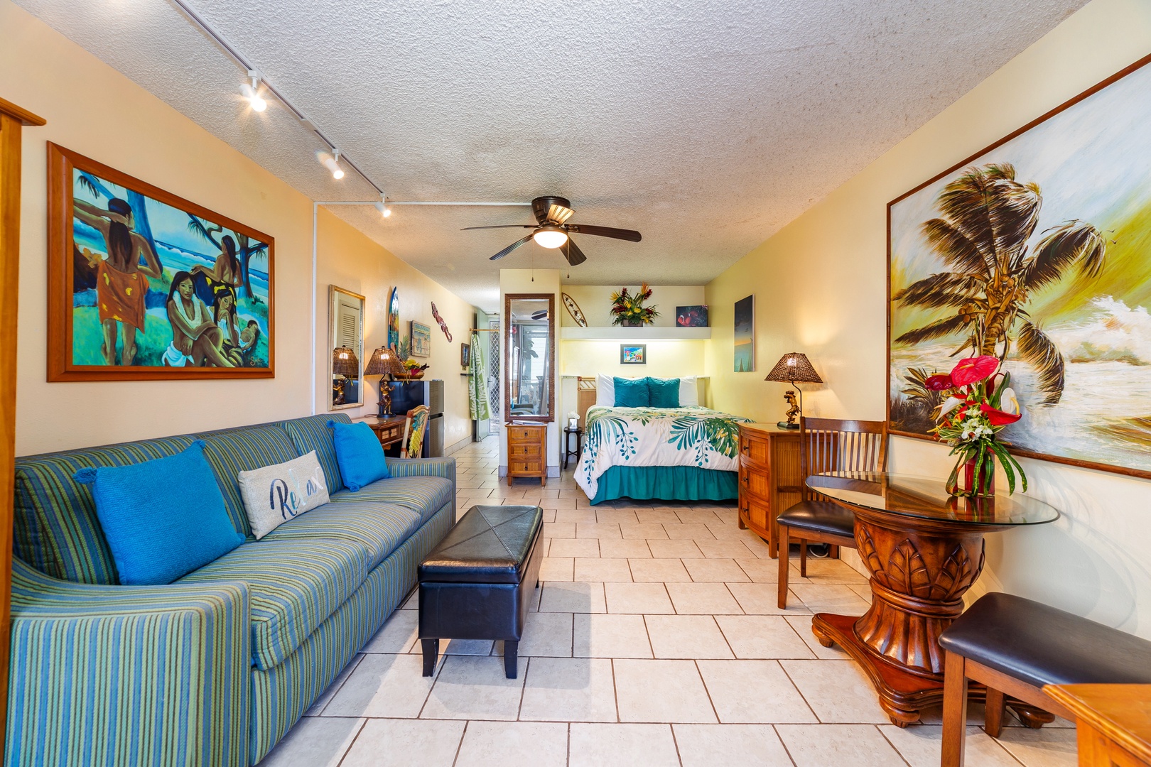 Sink into the island-inspired studio where tropical artwork, plush seating, and vibrant ocean hues invite you to unwind in effortless comfort.