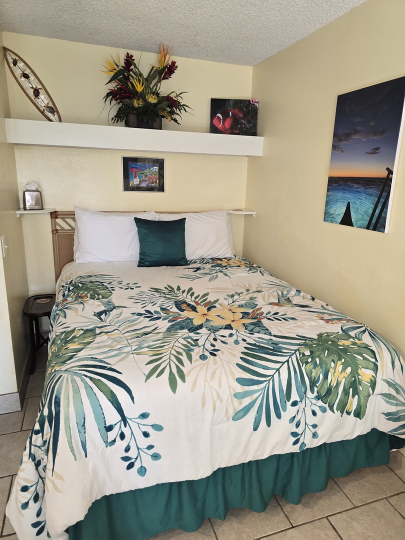 Unwind in your cozy bedroom with tropical-print bedding and thoughtful artwork creating a peaceful retreat.