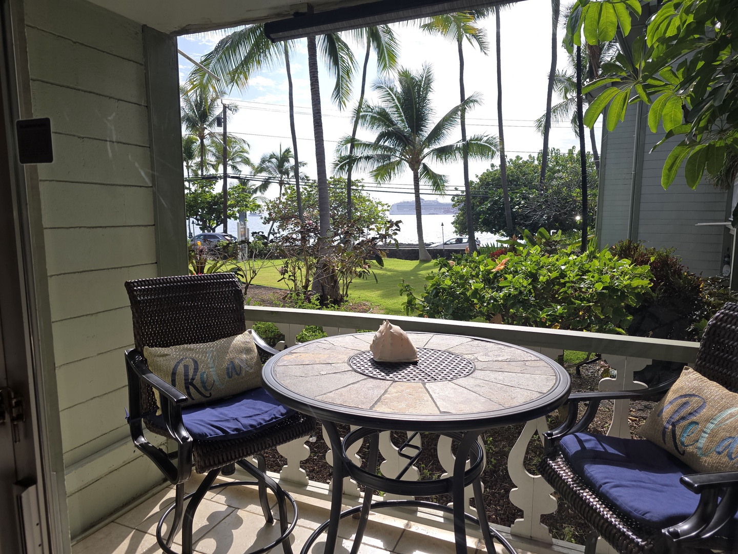 Sip your morning coffee at this charming patio table, surrounded by tropical palms and lush gardens with glimpses of the ocean beyond.