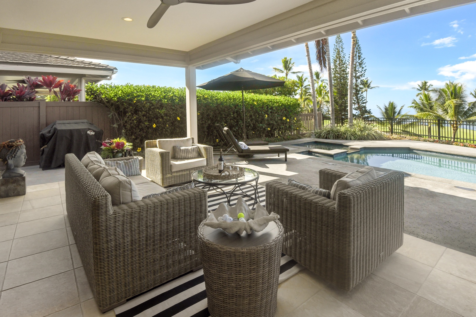 Unwind in your private covered lanai with stylish wicker seating overlooking the sparkling pool and tropical landscaping.