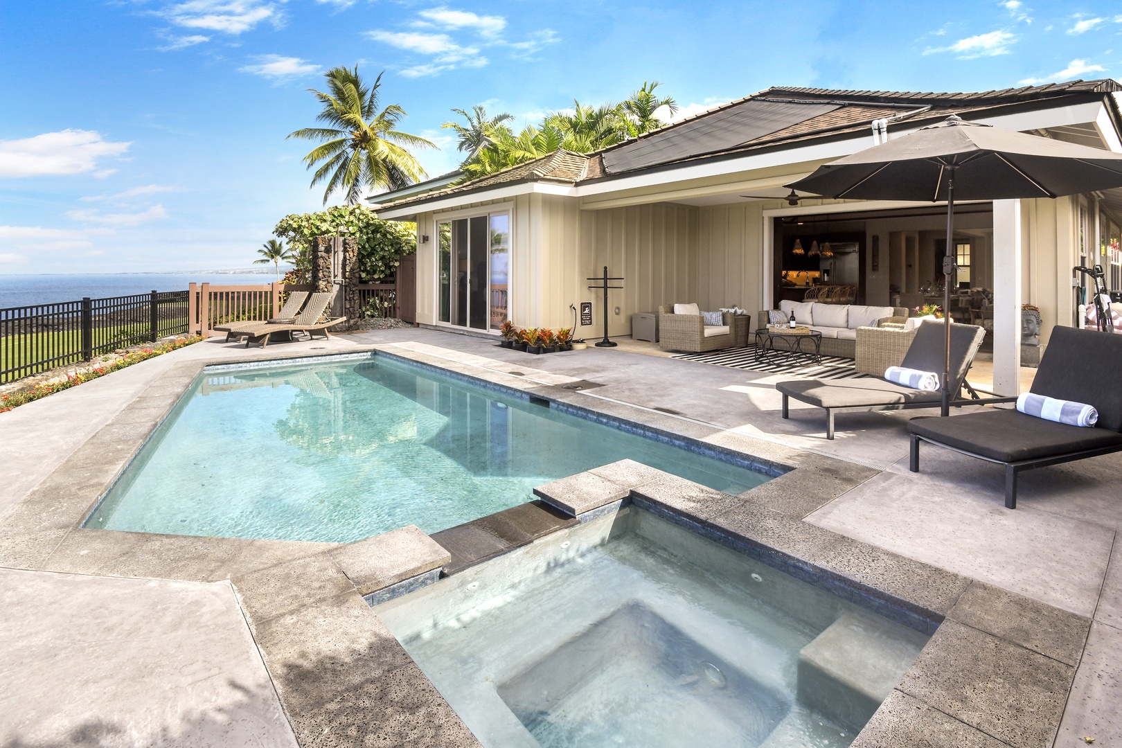 Your private tropical paradise features a sparkling pool and spa surrounded by swaying palms, perfect for soaking up Hawaiian sunshine.