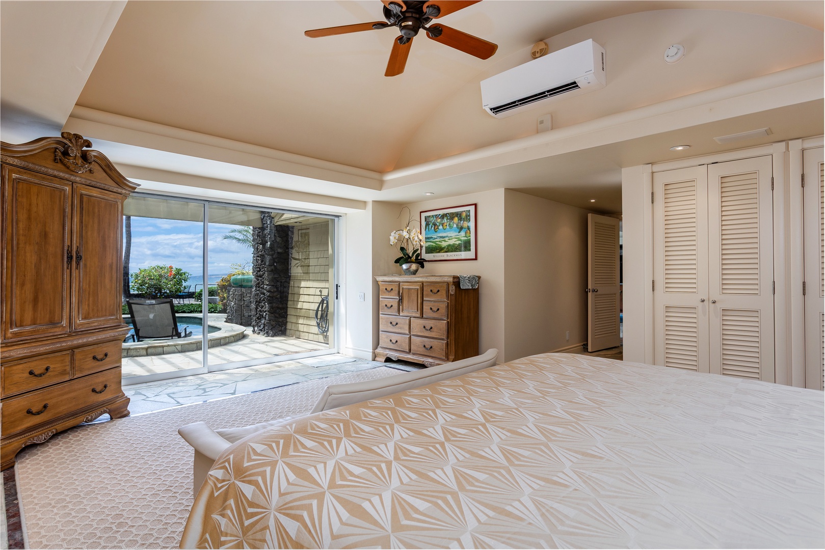 Primary Bedroom - Relax in your spacious bedroom where ocean views and tropical breezes meet comfort. Step through sliding doors to your private lanai, complete with a plunge pool, lush greenery and serene seating.