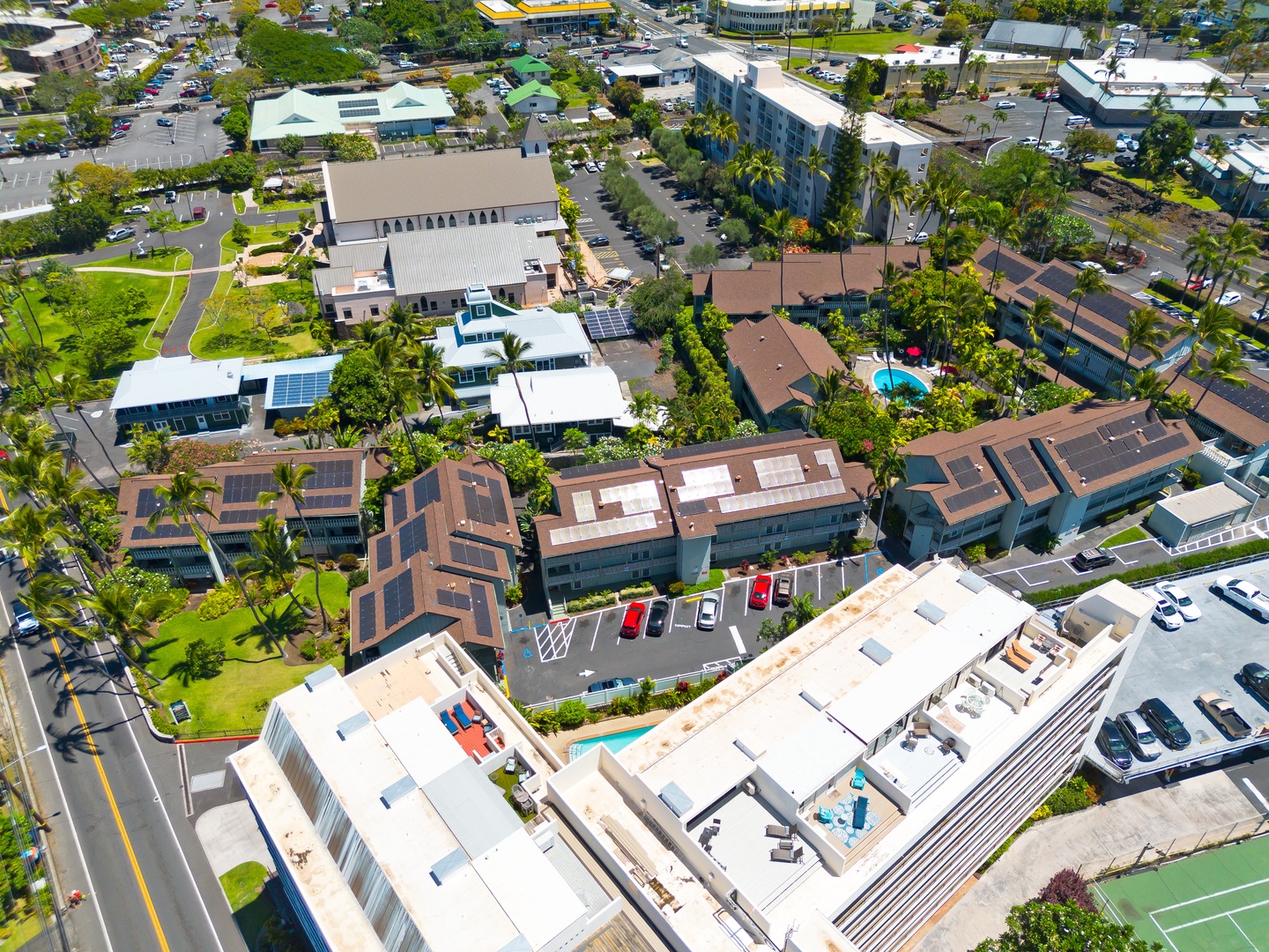 Aerial view of the property nestled in a vibrant neighborhood with convenient access to shops, dining, and local attractions, surrounded by lush greenery and residential streets.