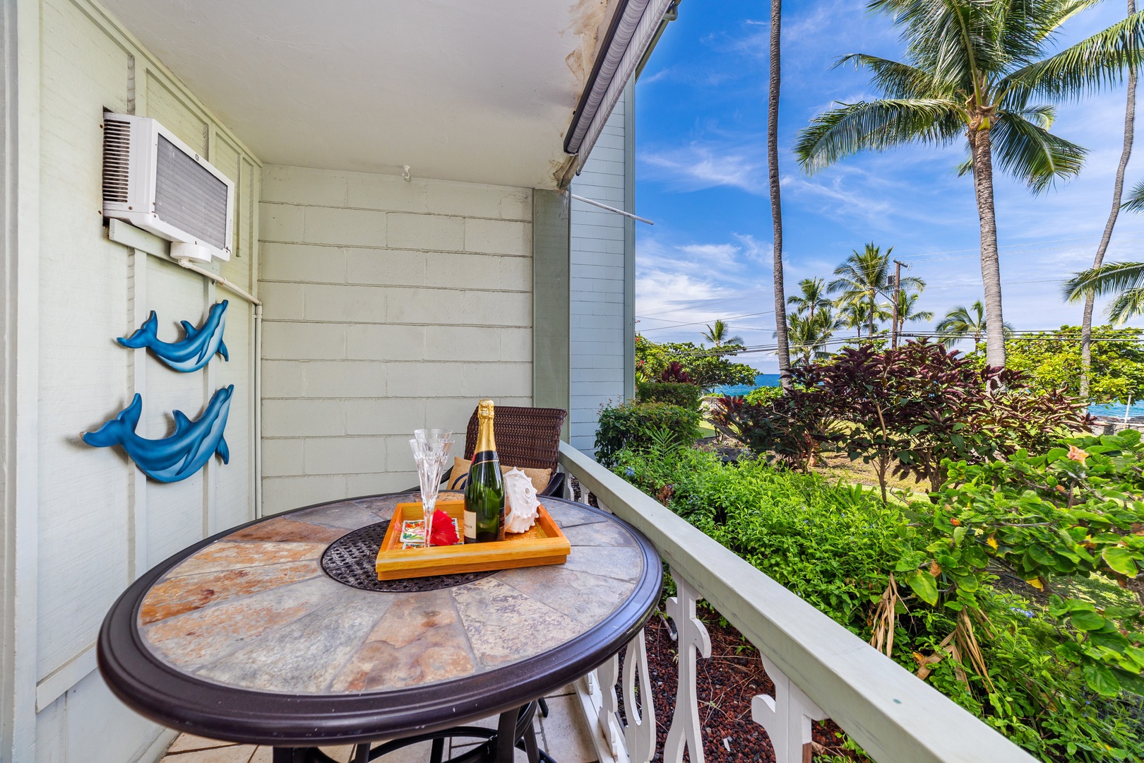 Sip champagne on your private lanai as swaying palms and tropical gardens frame glimpses of turquoise waters—a serene escape to unwind and celebrate paradise.