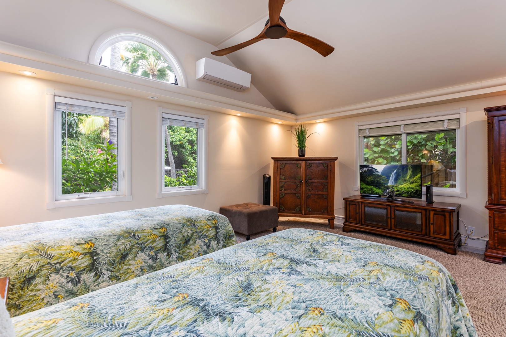 Guest Bedroom - Drift off in your spacious tropical sanctuary with plush bedding, soaring vaulted ceilings, and lush garden views framing your escape through bright windows.