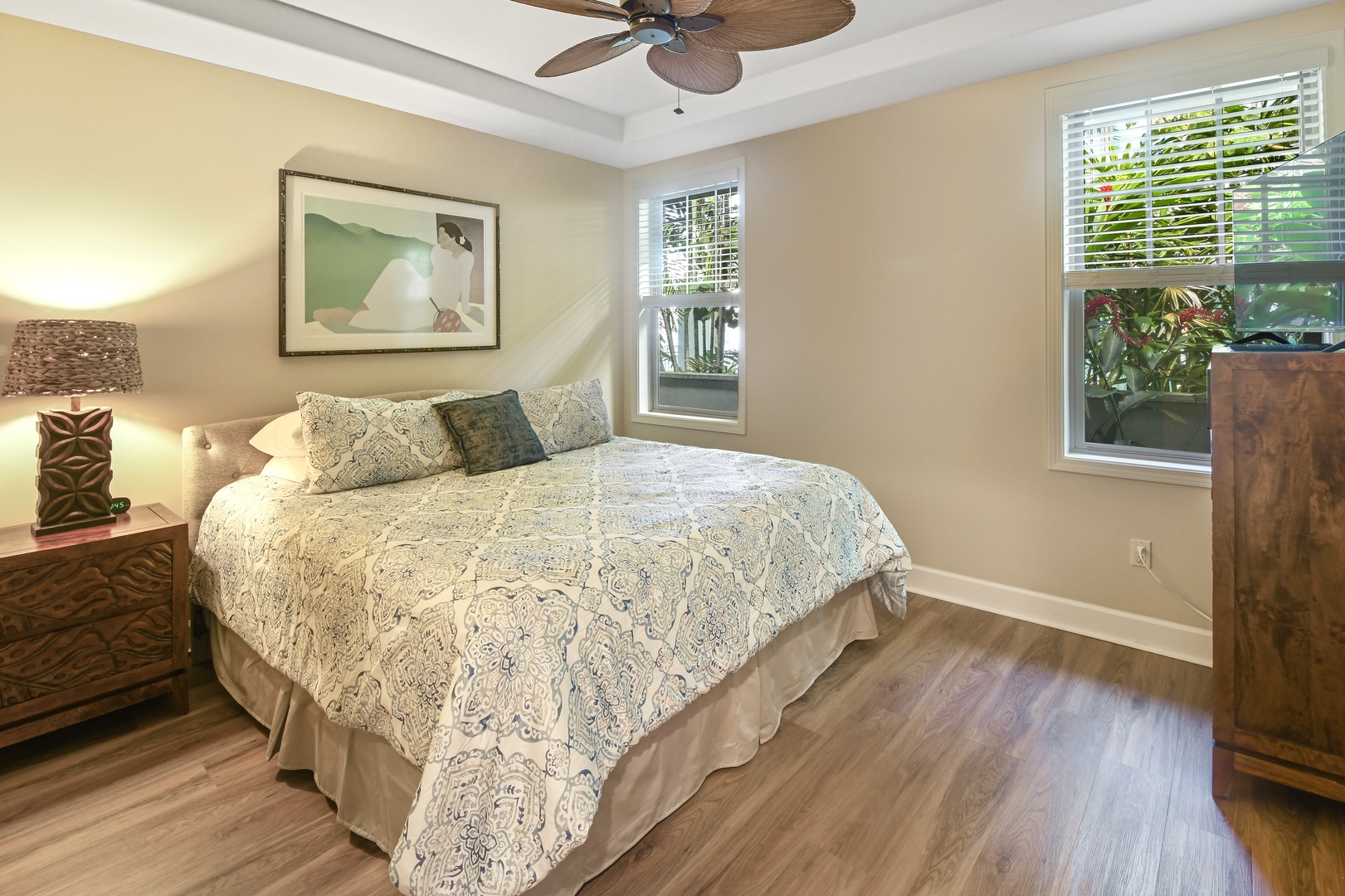 Sink into this serene bedroom where tropical breezes flow through your windows and a ceiling fan ensures perfect comfort all night long.