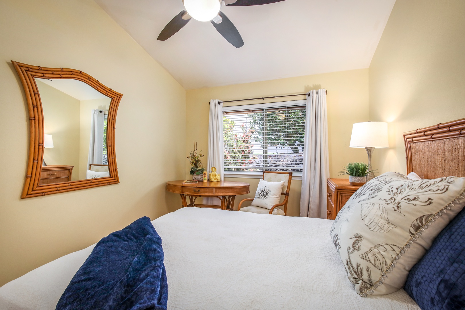 Relax in your cozy bedroom, where warm wood tones, a plush bed, and gentle ceiling fan breezes create a peaceful retreat. Natural light filters through the window, inviting restful mornings and serene evenings.