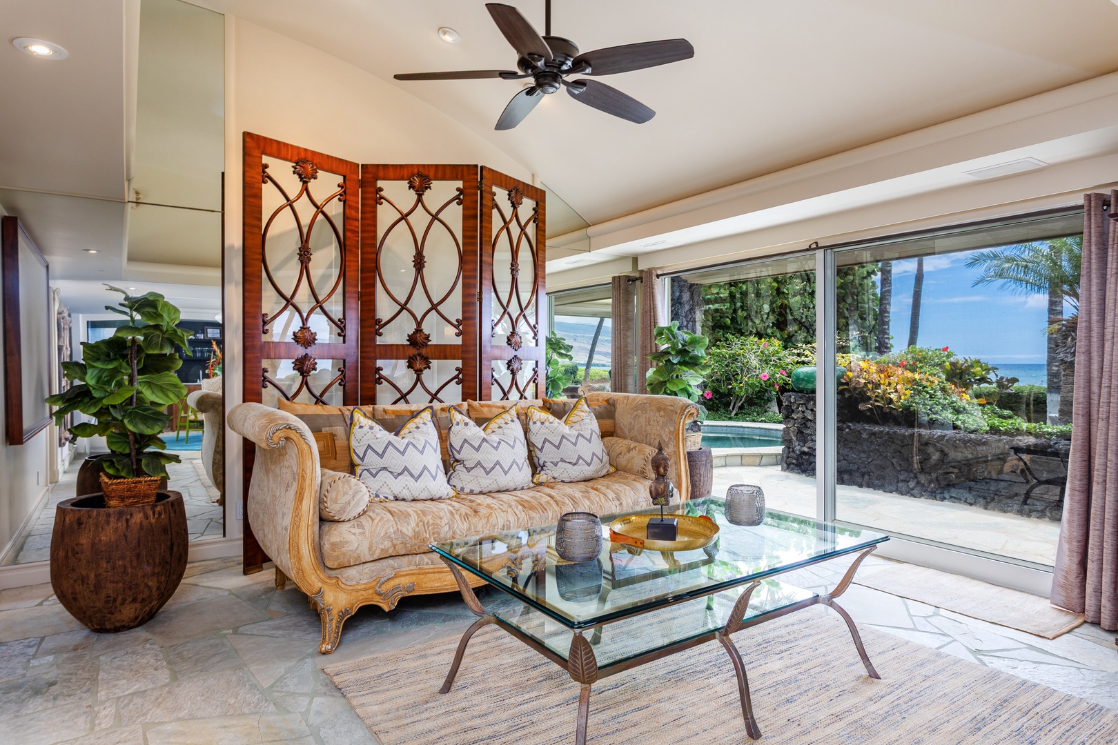 Unwind in your elegant living room, where tropical breezes meet island style. Sink into plush seating, sip your morning coffee, and gaze out at the sparkling pool and ocean beyond.