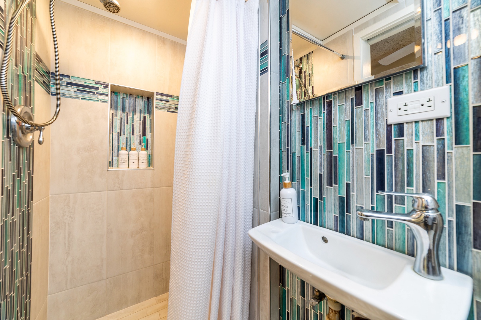 You'll love the elegant glass mosaic tilework that brings coastal color to your private bathroom. Step into your spacious walk-in shower with premium fixtures and finishes.