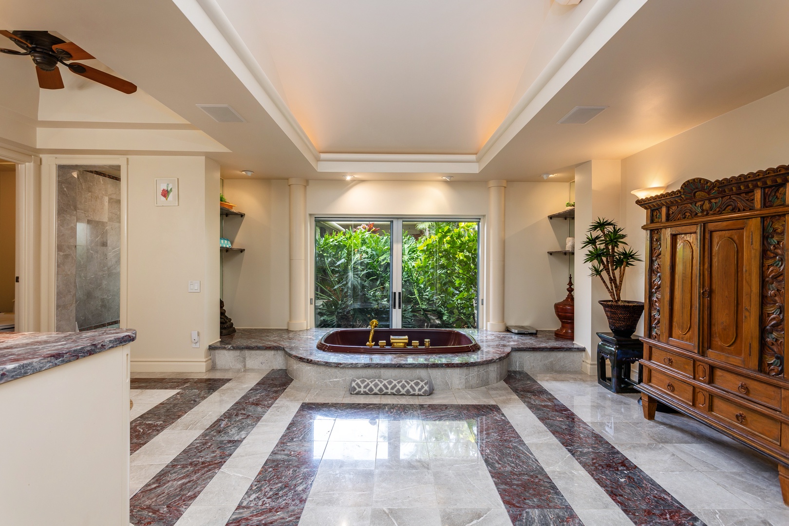 Primary Bathroom - Sink into the elegant sunken tub framed by garden views, where luxurious marble floors and ornate wood furnishings create your private spa sanctuary for ultimate relaxation.