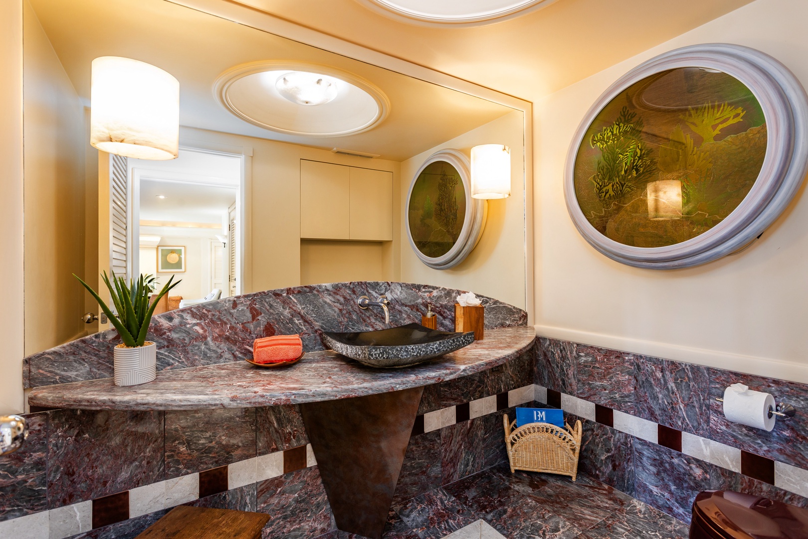 Powder Room - Unwind in this elegantly designed bathroom featuring striking marbled stone, a unique vessel sink, and warm ambient lighting that creates your personal spa retreat.