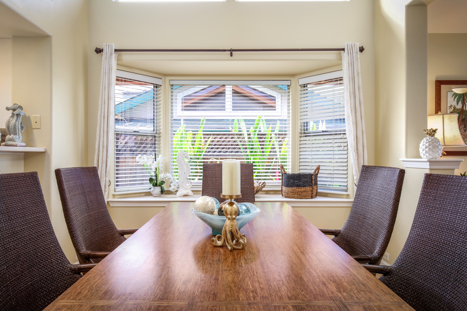 Gather around the elegant dining table with seating for six, bathed in natural light from the bay window overlooking lush greenery—perfect for shared meals and cherished moments together.