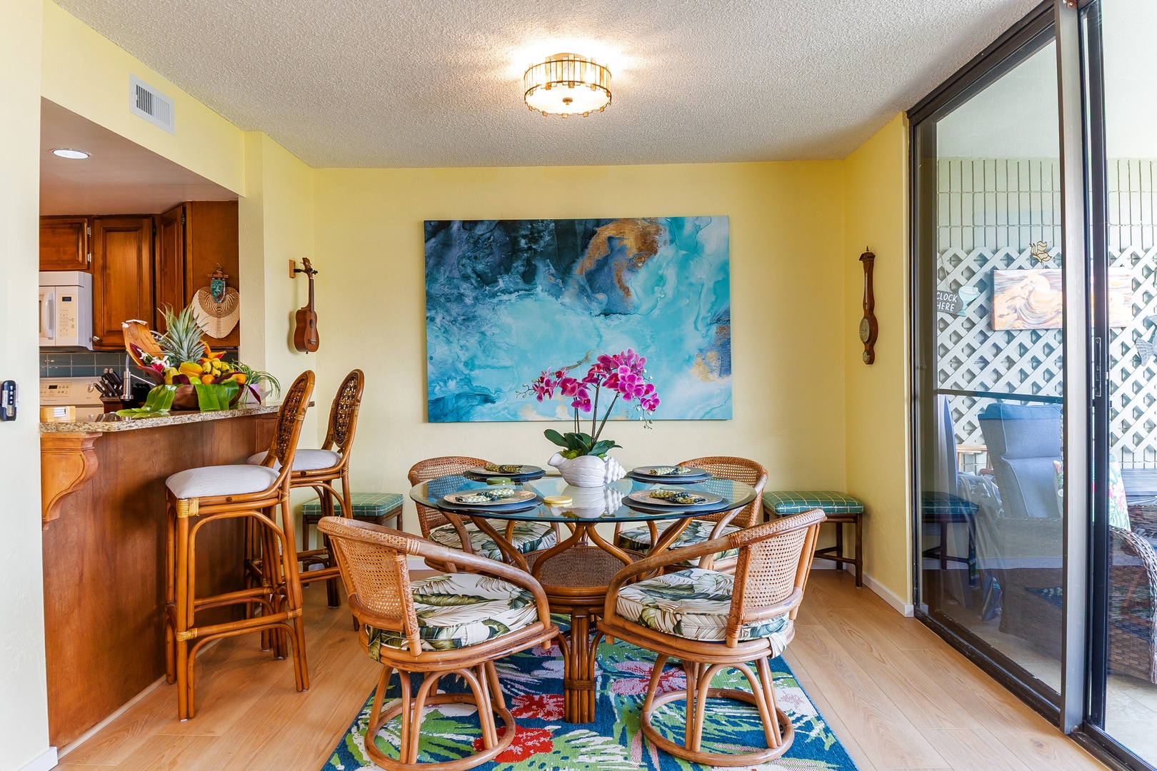 Gather around this inviting dining space, where warm tropical tones and woven rattan chairs create the perfect setting for your morning coffee or shared meals. Just beyond, your private balcony awaits.