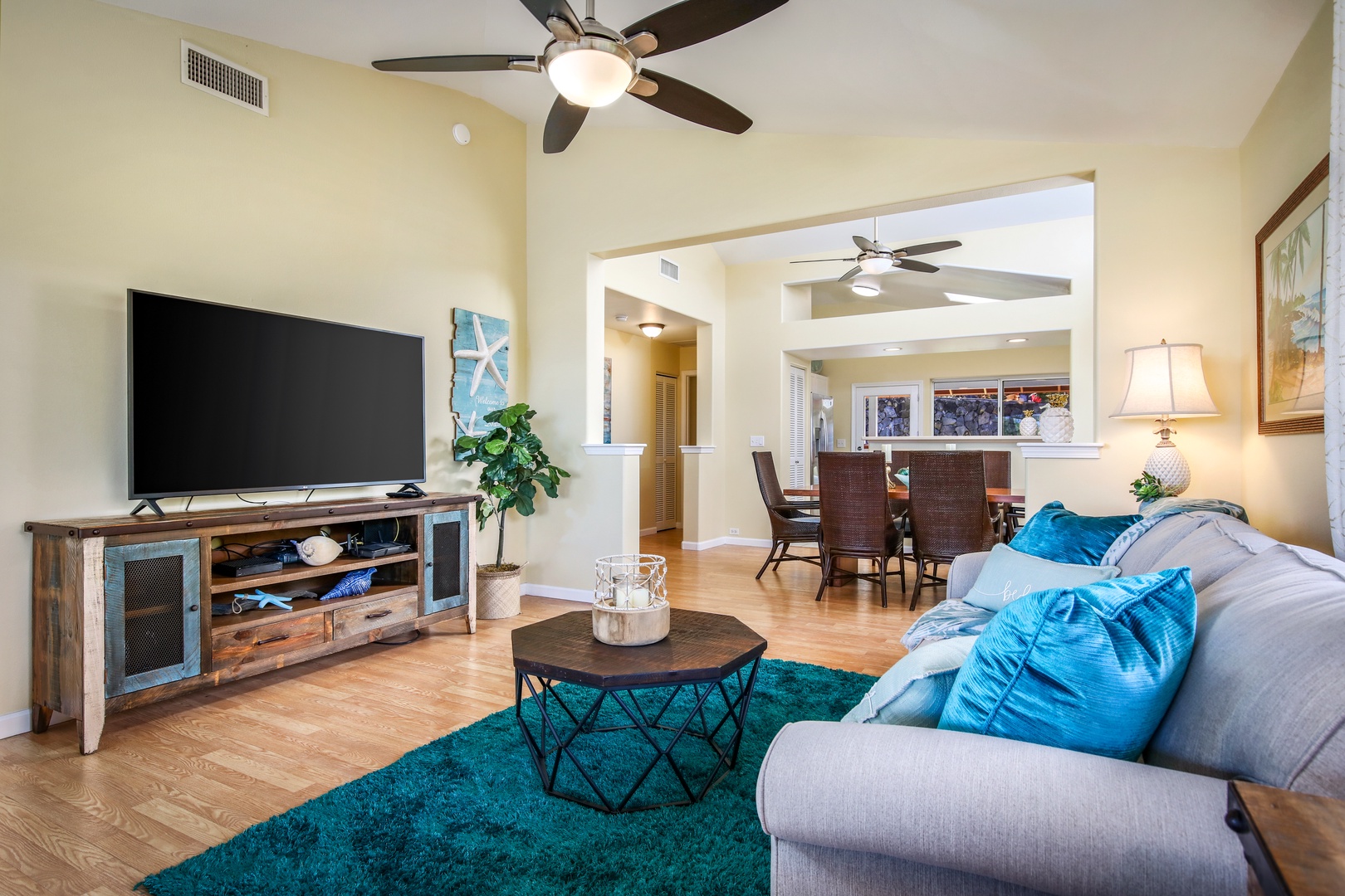 Sink into plush seating and unwind in this bright, open living space where ceiling fans keep you cool and the entertainment center awaits your movie nights.