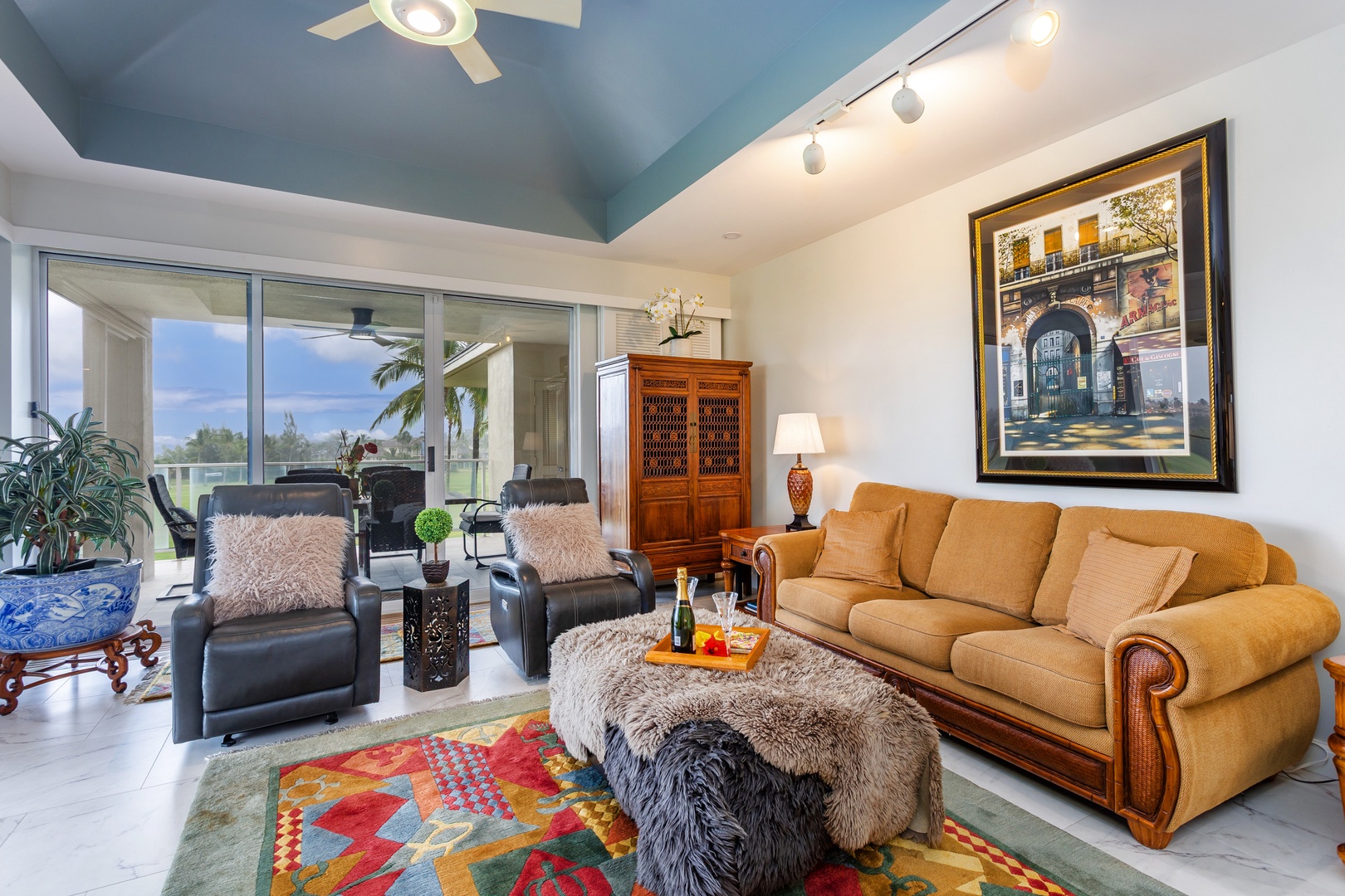 Unwind in your inviting living room, where vaulted ceilings and a soothing blue palette create an airy retreat. Sink into plush seating and enjoy tropical garden views through expansive glass doors.