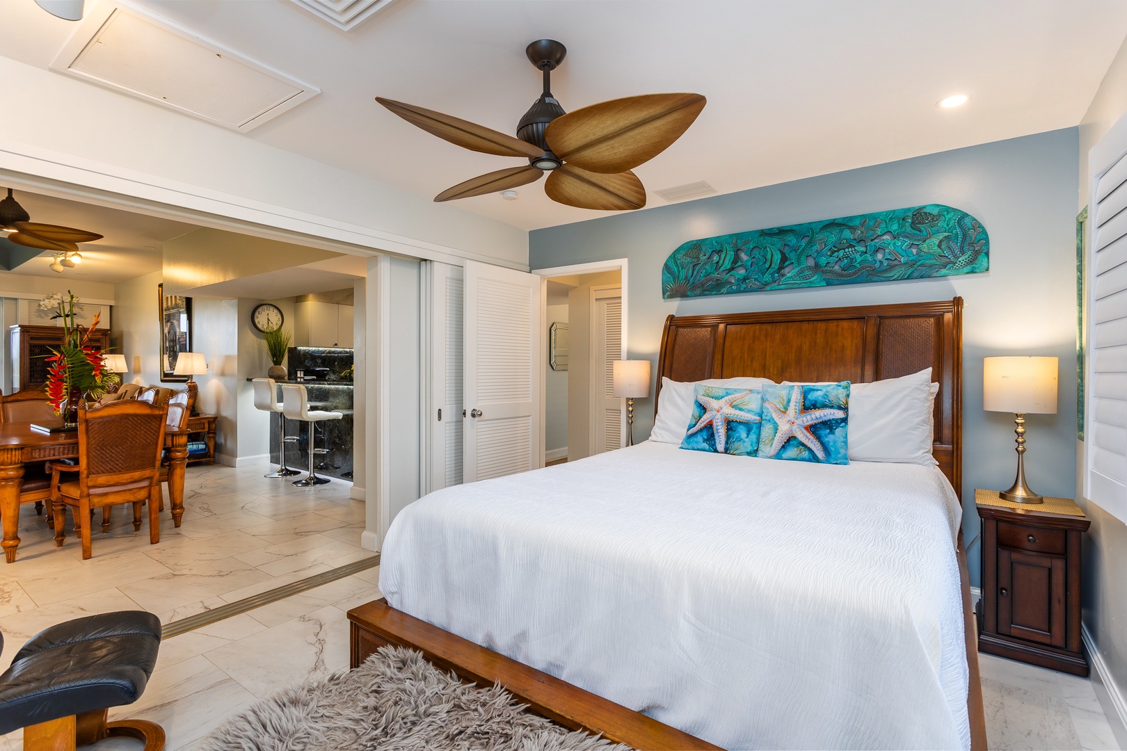 Unwind in your serene bedroom, where crisp white linens and coastal-inspired accents create a peaceful retreat. Gentle breezes from the ceiling fan and soft bedside lighting invite you to relax completely.