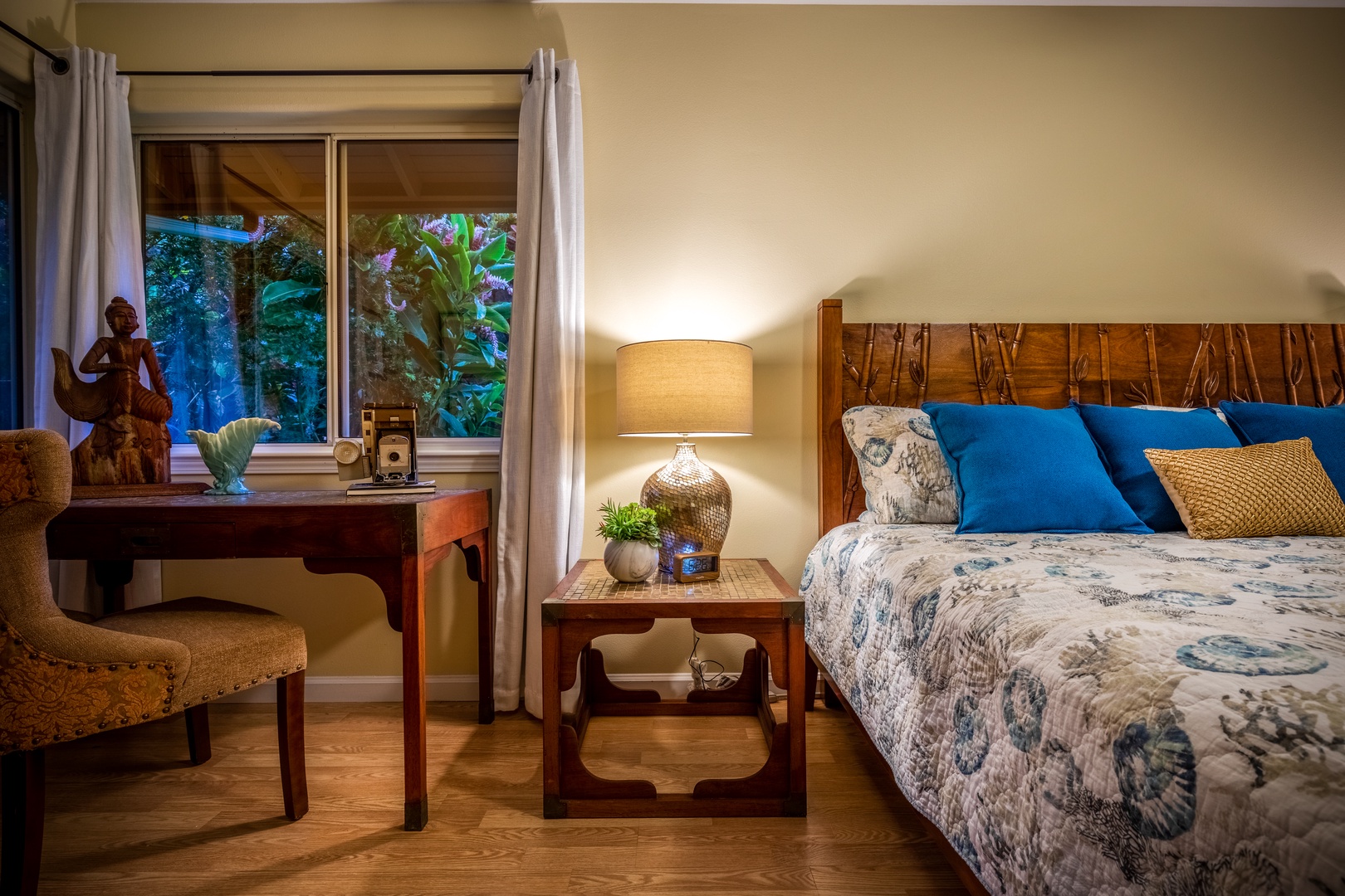 Sink into a peaceful night's rest on a plush bed surrounded by warm wood accents, soft lighting, and a tranquil garden view through your window.