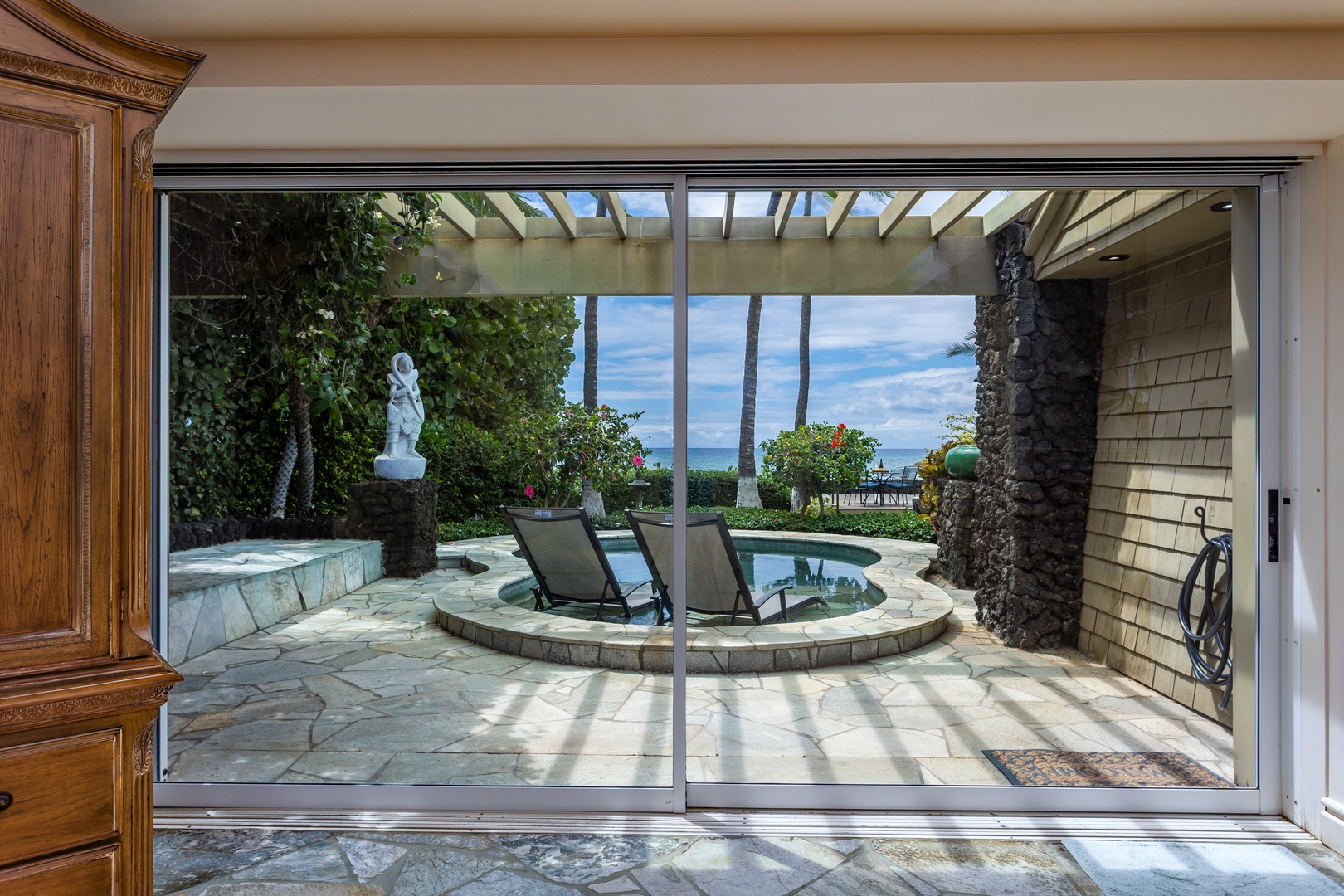 Just outside the primary bedroom, step through into your own private oasis where a sun-drenched patio with plunge pool awaits, framed by lush greenery and ocean views that invite pure relaxation.