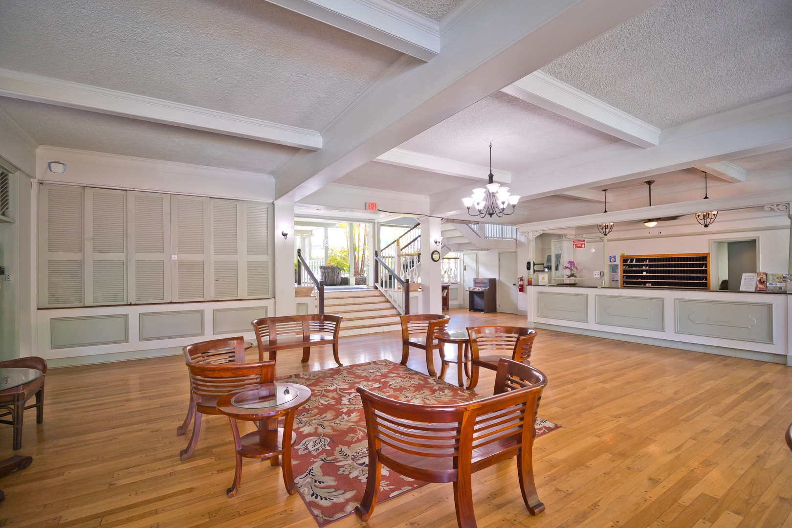 A spacious lobby welcomes you with warm wood floors, elegant chandeliers, and a bright reception desk ready to make your check-in effortless and inviting.