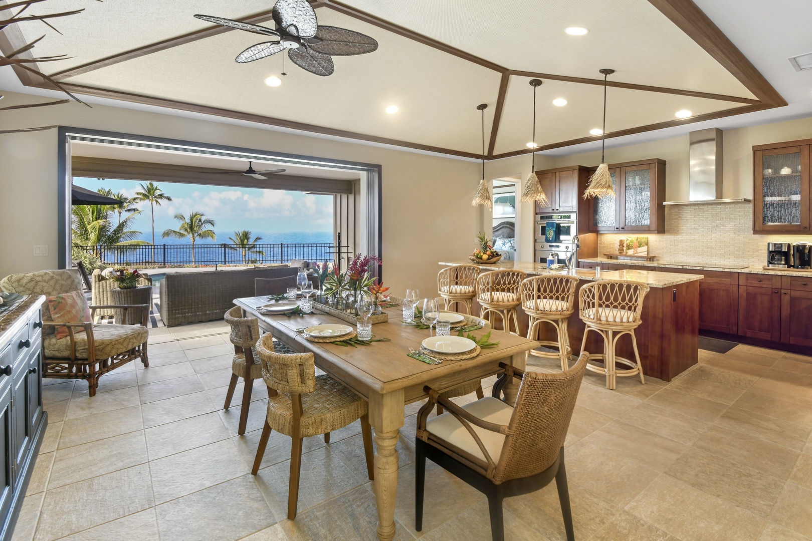 Savor meals in this stunning open-concept dining and kitchen space with breathtaking ocean views through expansive sliding glass doors.