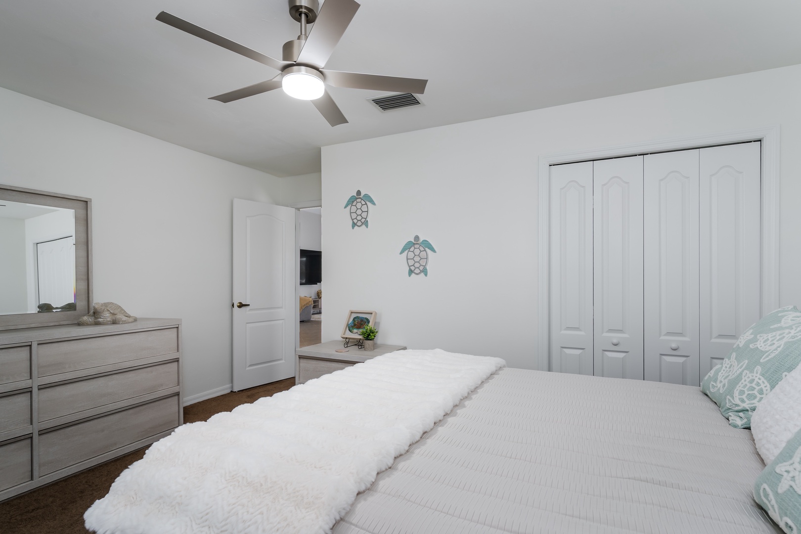 Relax in your peaceful bedroom with coastal vibes, complete with a ceiling fan and ample storage space.