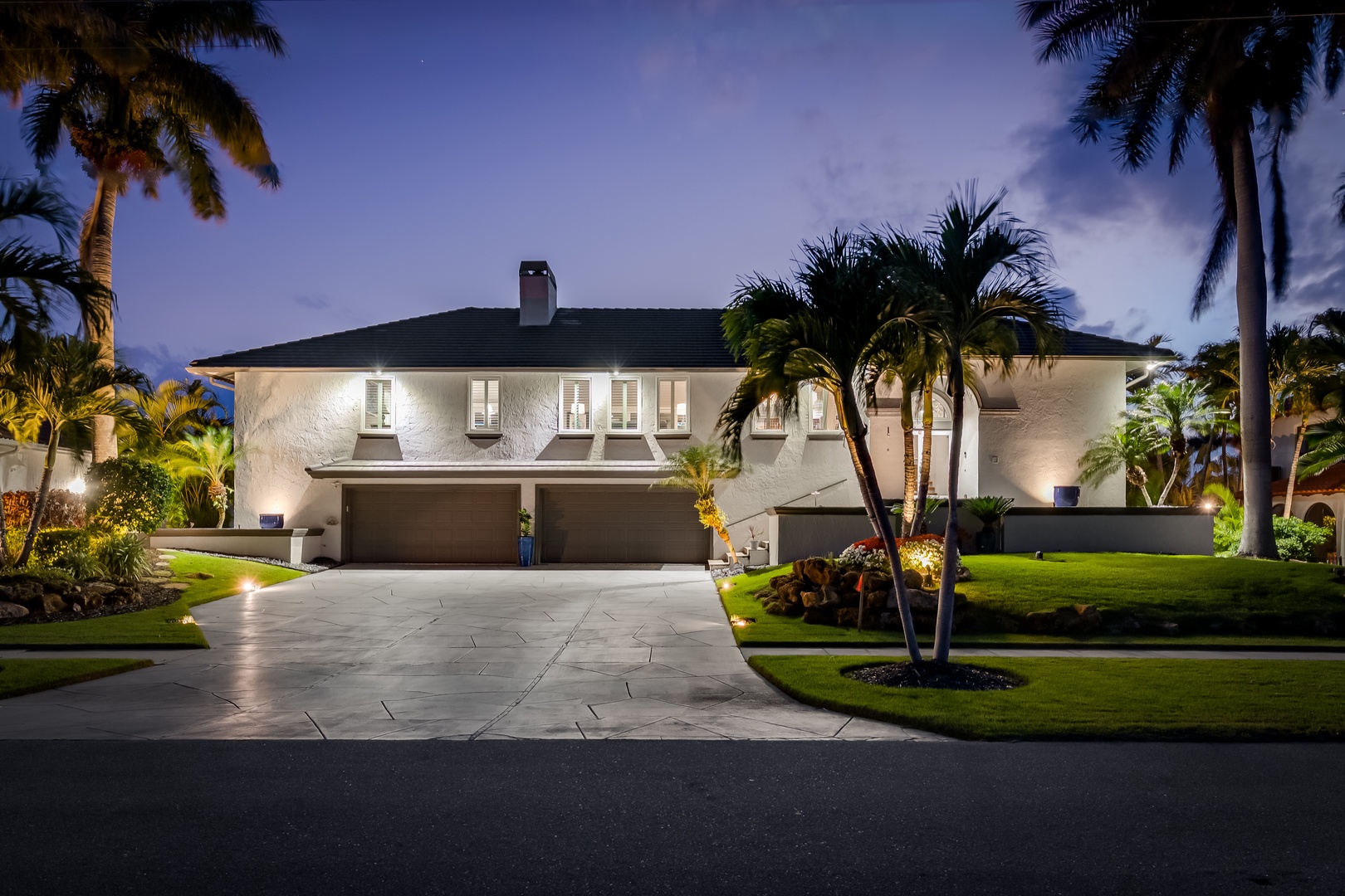A stunning tropical estate framed by swaying palms, featuring elegant architecture and manicured grounds that welcome guests to an island paradise retreat.