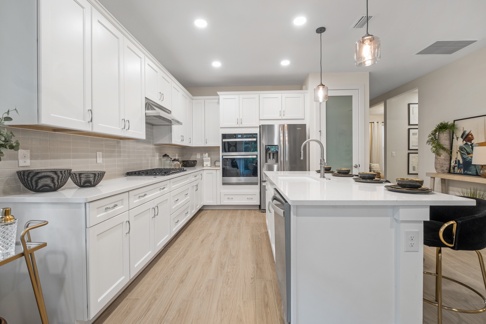 Your gourmet kitchen features sleek white cabinetry, quartz countertops, and stainless steel appliances perfect for creating memorable meals together.