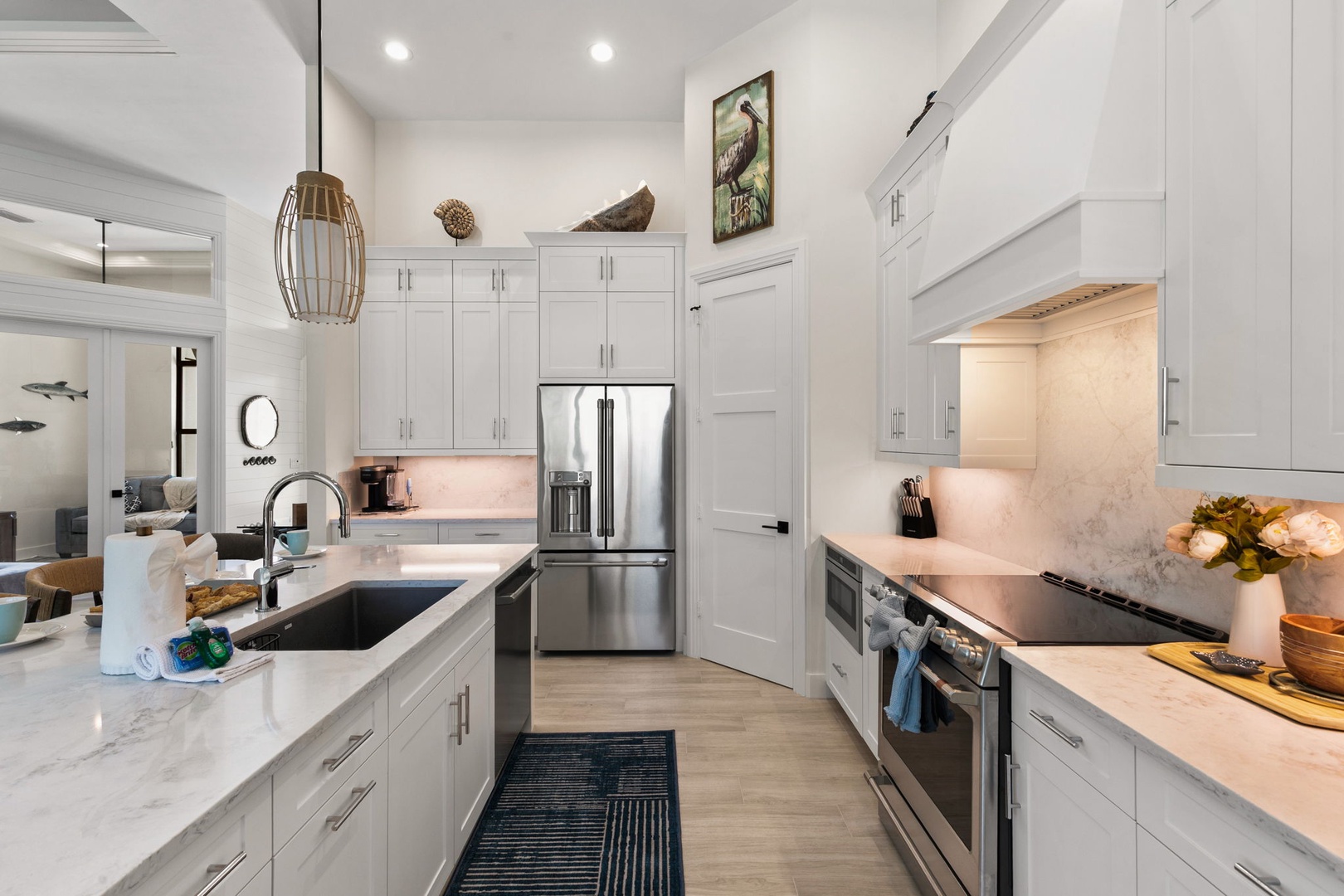 Your gourmet kitchen awaits with gleaming marble countertops, stainless steel appliances, and coastal-inspired touches that make meal prep a pleasure.