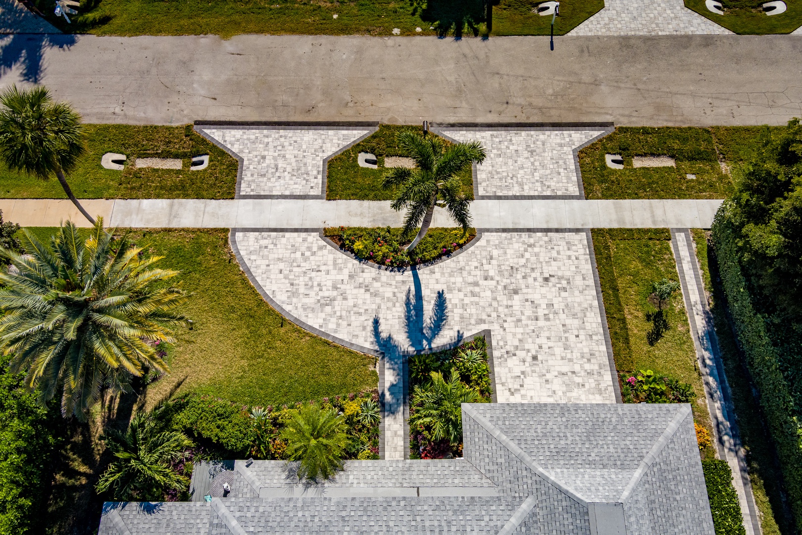 Aerial view of the property showing tropical landscaping with palm trees and manicured gardens surrounding the building.
