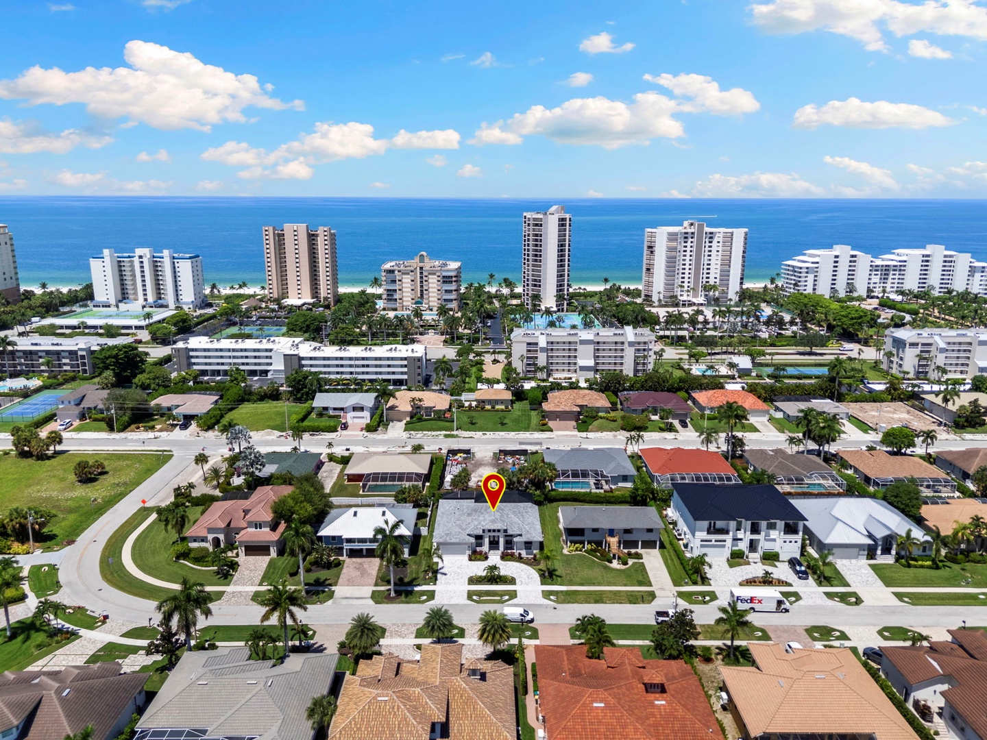 This vacation rental sits in a charming coastal neighborhood with the ocean and beach just a short distance away, surrounded by palm trees and waterfront high-rises.