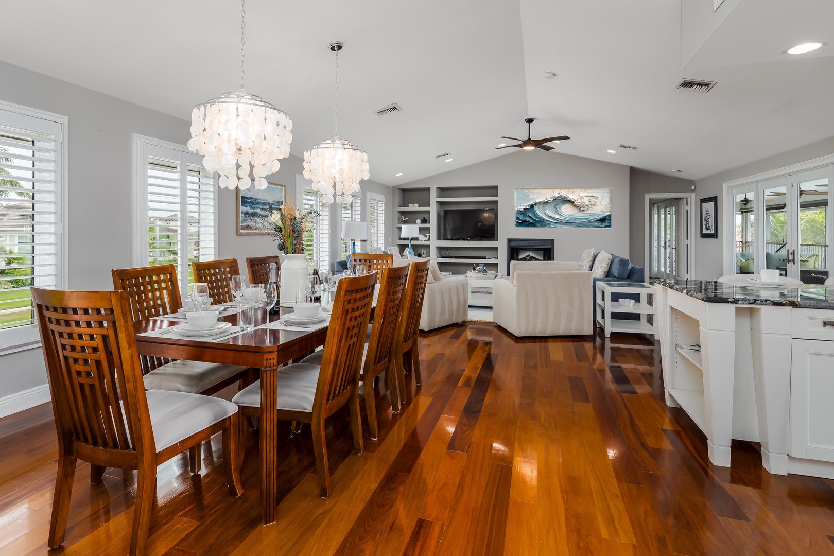 Gather around the elegant dining table beneath shimmering chandeliers, then unwind in your open-concept living space where gleaming hardwood floors invite you to relax and make memories.