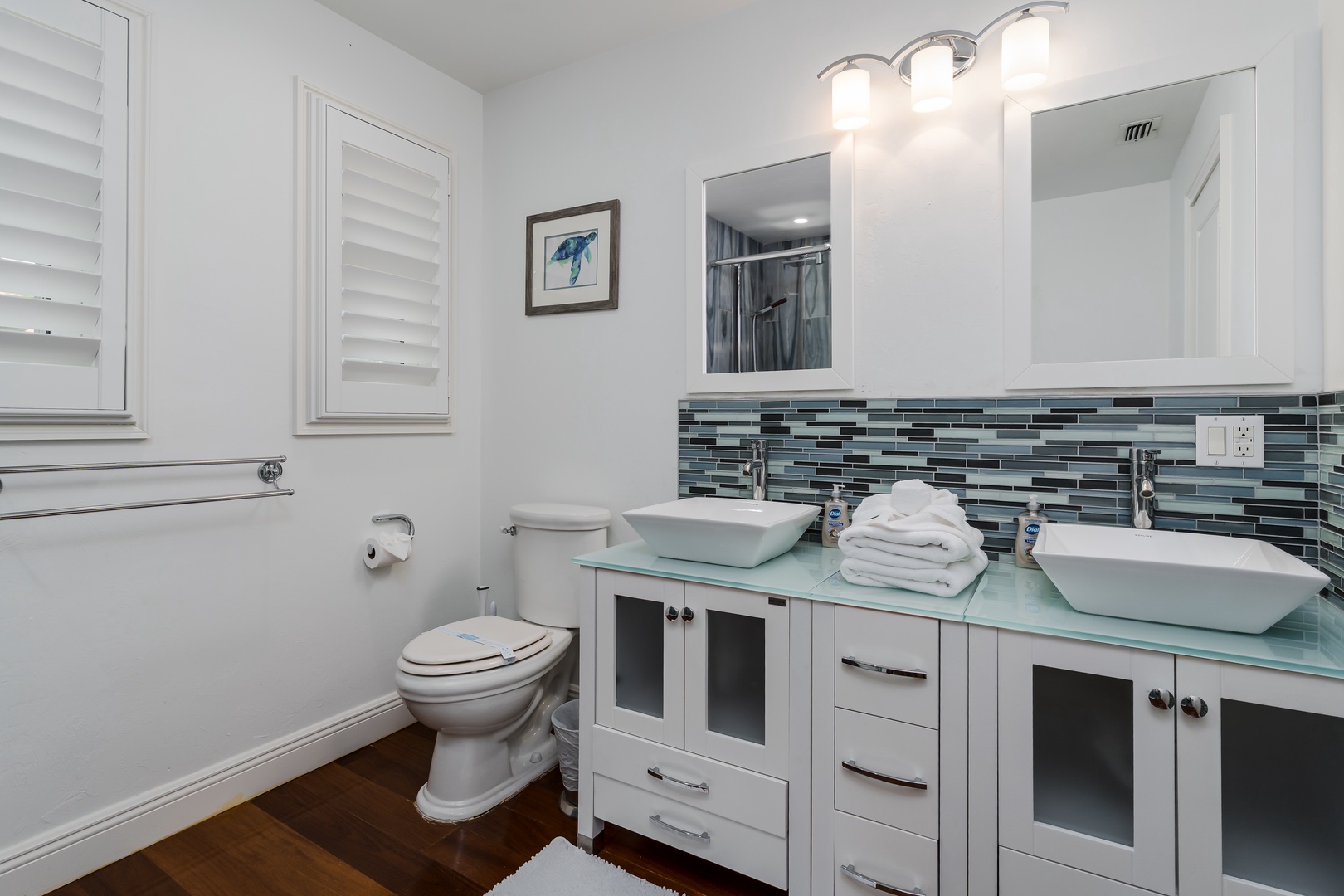 Freshen up in style with dual vessel sinks, modern glass tile accents, and plush towels—your private retreat awaits.