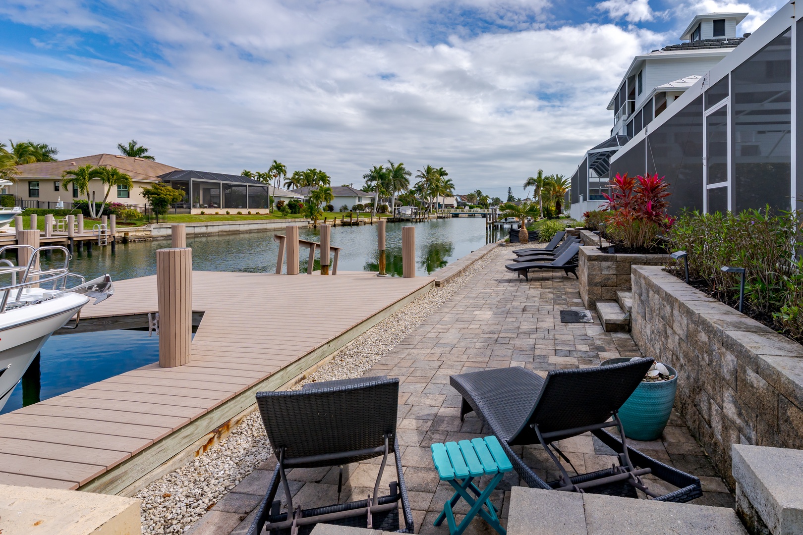 Waterfront property featuring a private dock and canal access with tropical landscaping and neighboring homes.