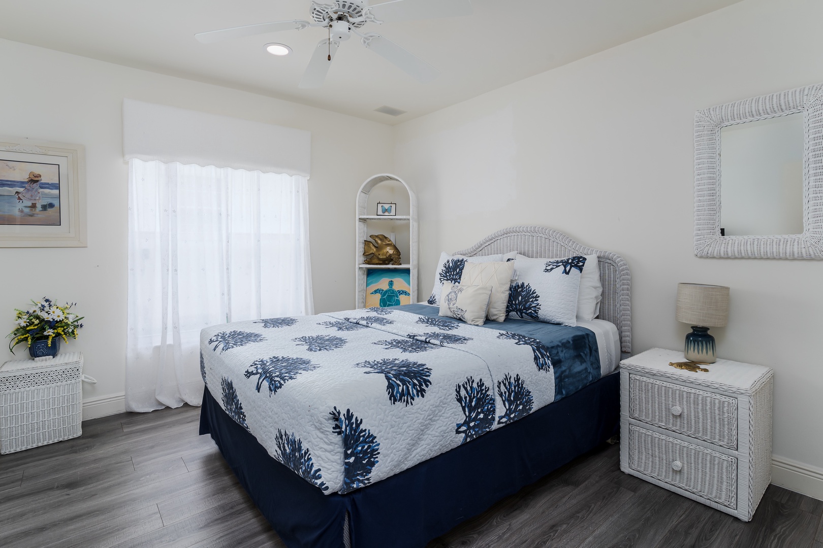 Slip into crisp, coastal comfort in your serene bedroom featuring a plush bed, airy natural light, and charming nautical accents throughout the space.