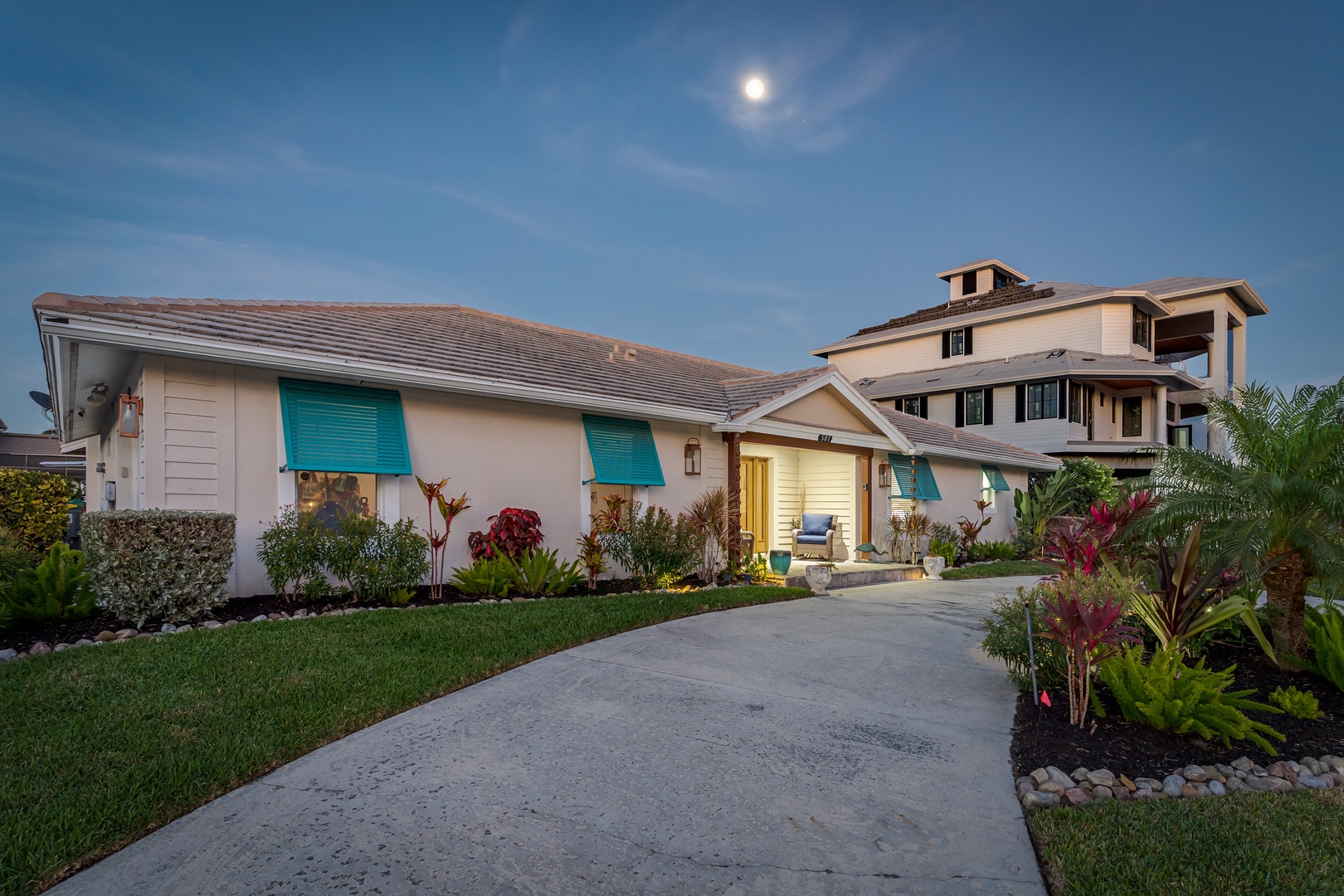 Contemporary beachside home with tropical landscaping and peaceful moonlit arrival experience.